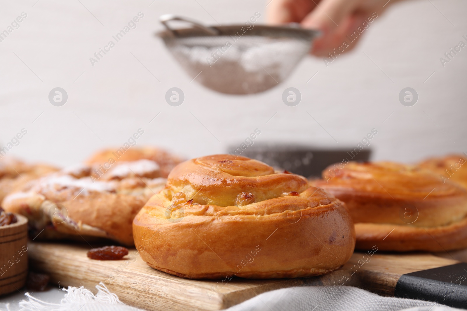 Photo of Delicious rolls with raisins on table, closeup. Sweet buns