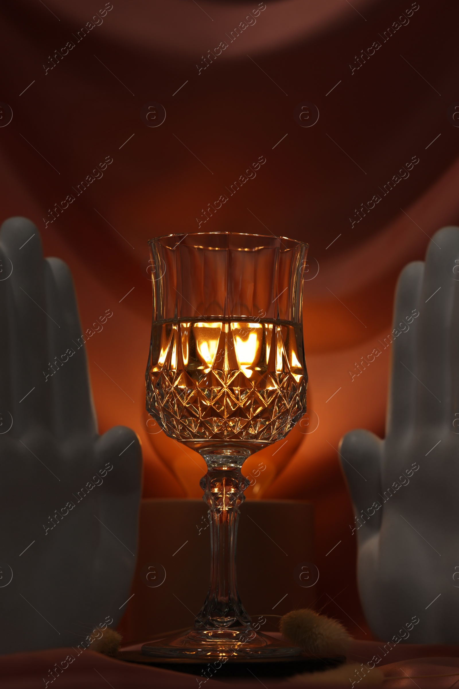 Photo of Stylish composition with glass of alcoholic drink and decor on color fabric