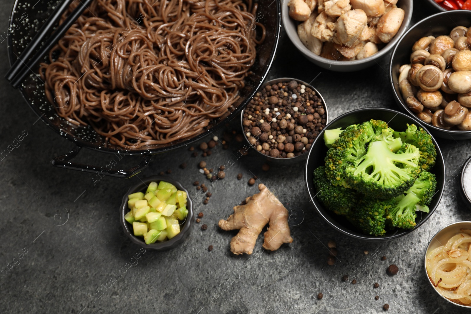 Photo of Wok with noodles, chicken and other products on grey table, above view