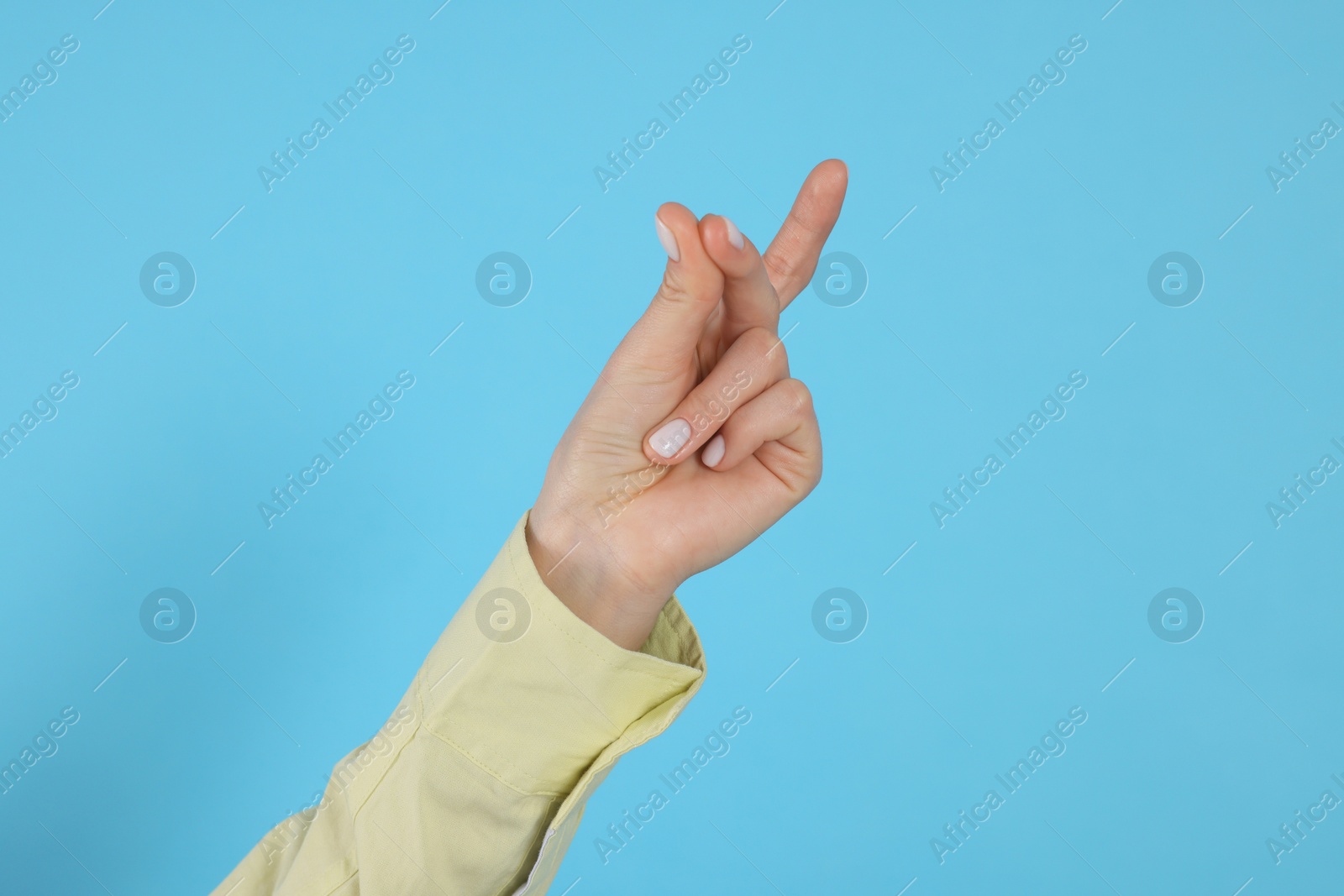 Photo of Woman snapping fingers on light blue background, closeup of hand