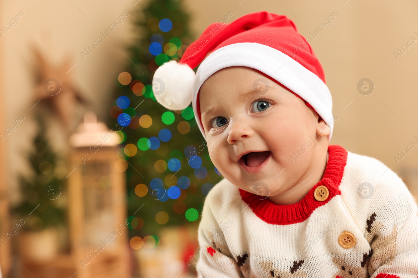 Photo of Cute little baby in Christmas sweater and Santa hat at home, space for text. Winter holiday