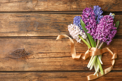 Photo of Beautiful spring hyacinth flowers on wooden table, top view. Space for text