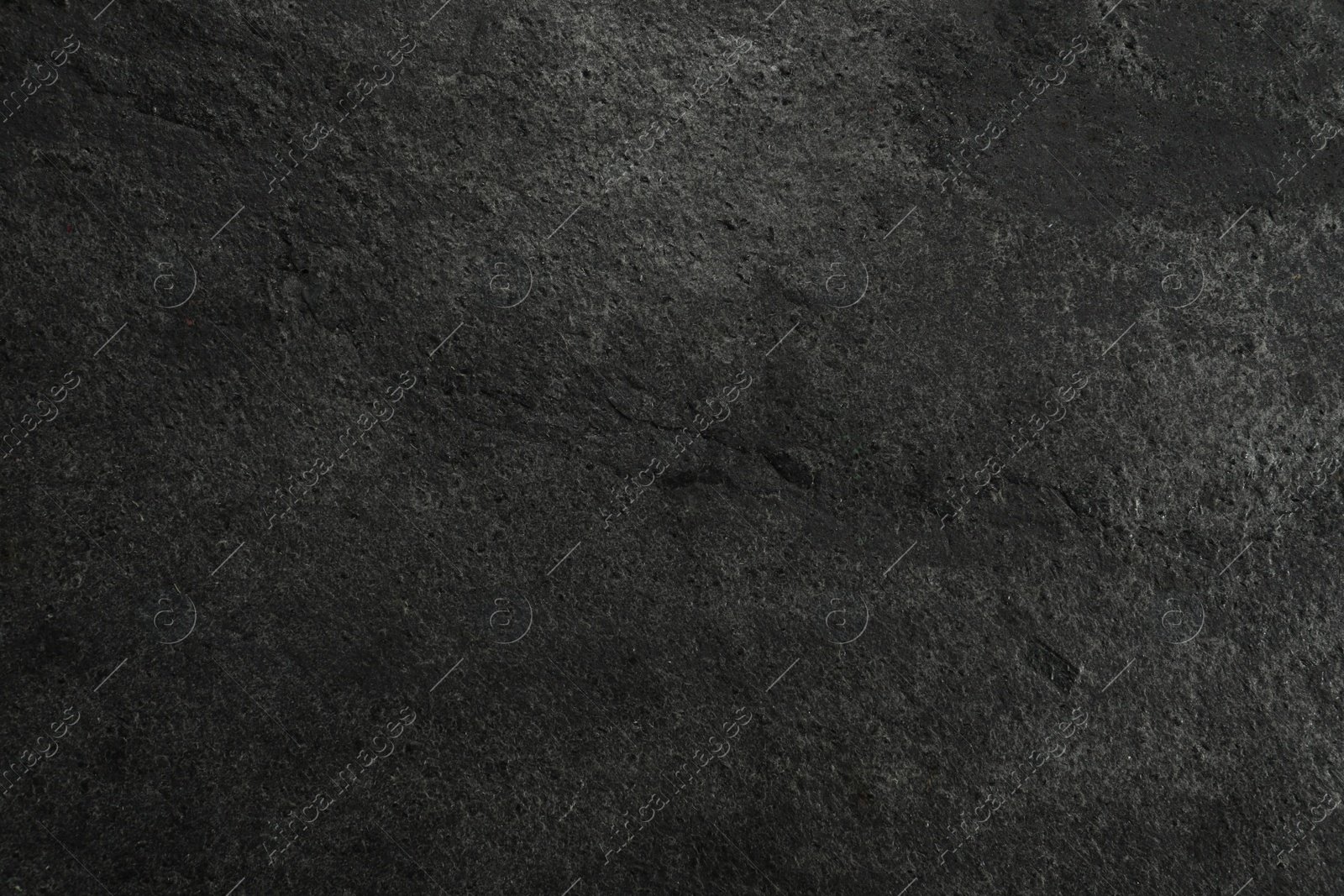 Photo of Texture of dark grey stone surface as background, closeup