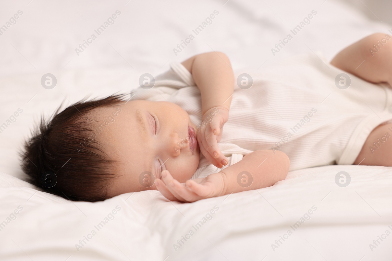 Photo of Cute newborn baby sleeping on white bed