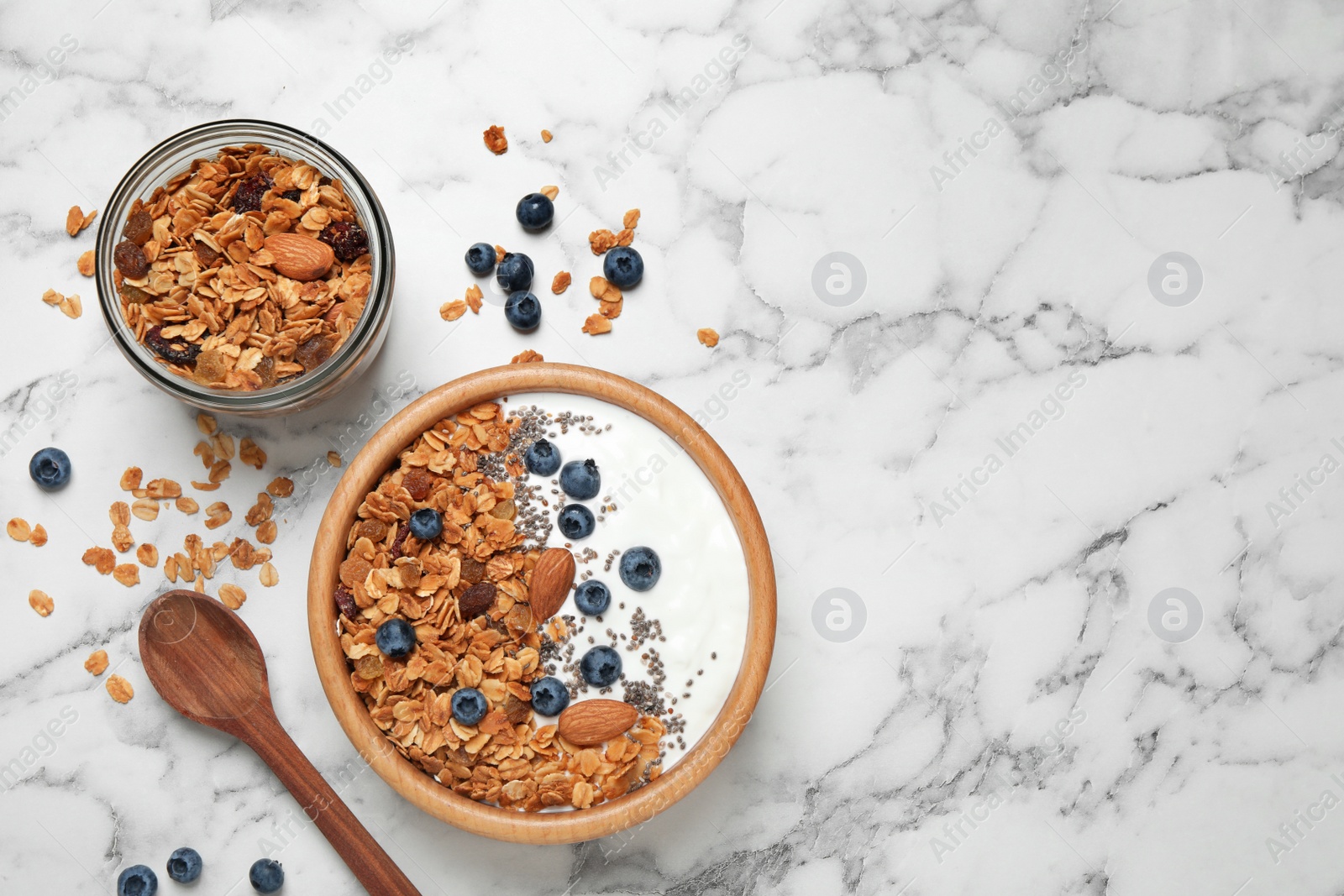 Photo of Tasty homemade granola served on white marble table, flat lay with space for text. Healthy breakfast