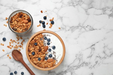 Photo of Tasty homemade granola served on white marble table, flat lay with space for text. Healthy breakfast