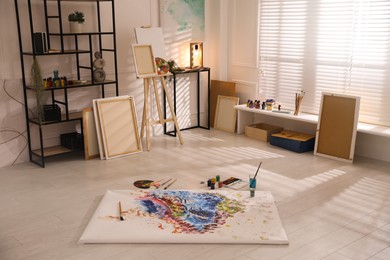 Photo of Wooden easel and abstract picture in art studio