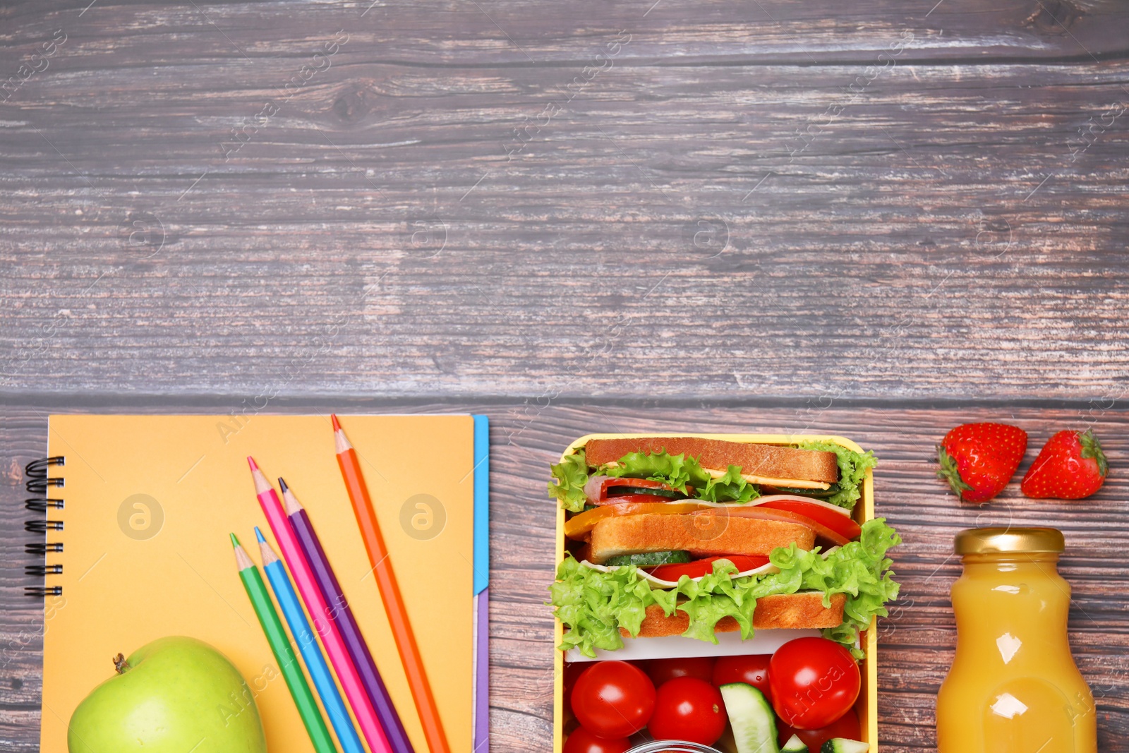 Photo of Lunch box with healthy food and different stationery on wooden table, flat lay. Space for text