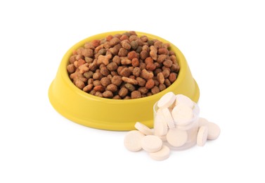 Photo of Dry pet food in bowl and vitamins isolated on white