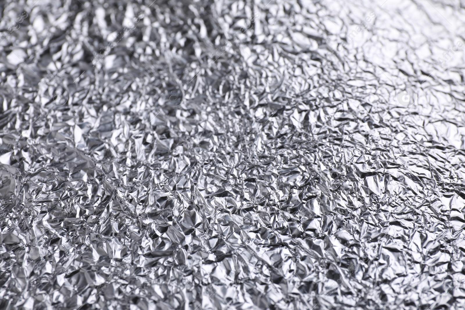 Photo of Crumpled silver foil as background, closeup view