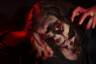 Photo of Scary zombie on dark background, closeup. Halloween monster