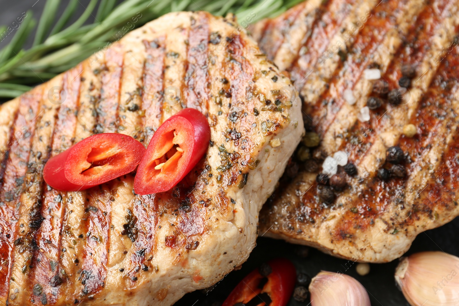 Photo of Delicious grilled pork steaks with spices on table, closeup