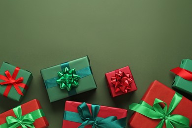Photo of Many gift boxes on dark green background, flat lay. Space for text
