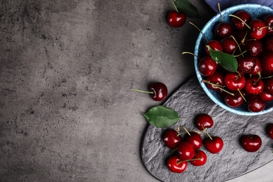 Photo of Flat lay composition with sweet cherries on grey table. Space for text