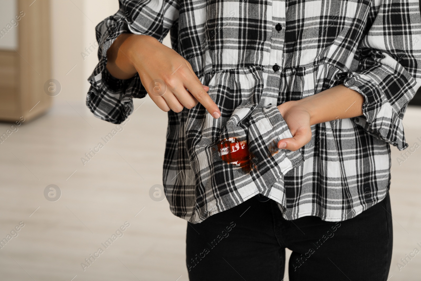 Photo of Woman showing sauce stain on her shirt indoors, closeup. Space for text