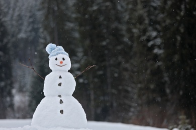 Adorable smiling snowman outdoors on winter day. Space for text