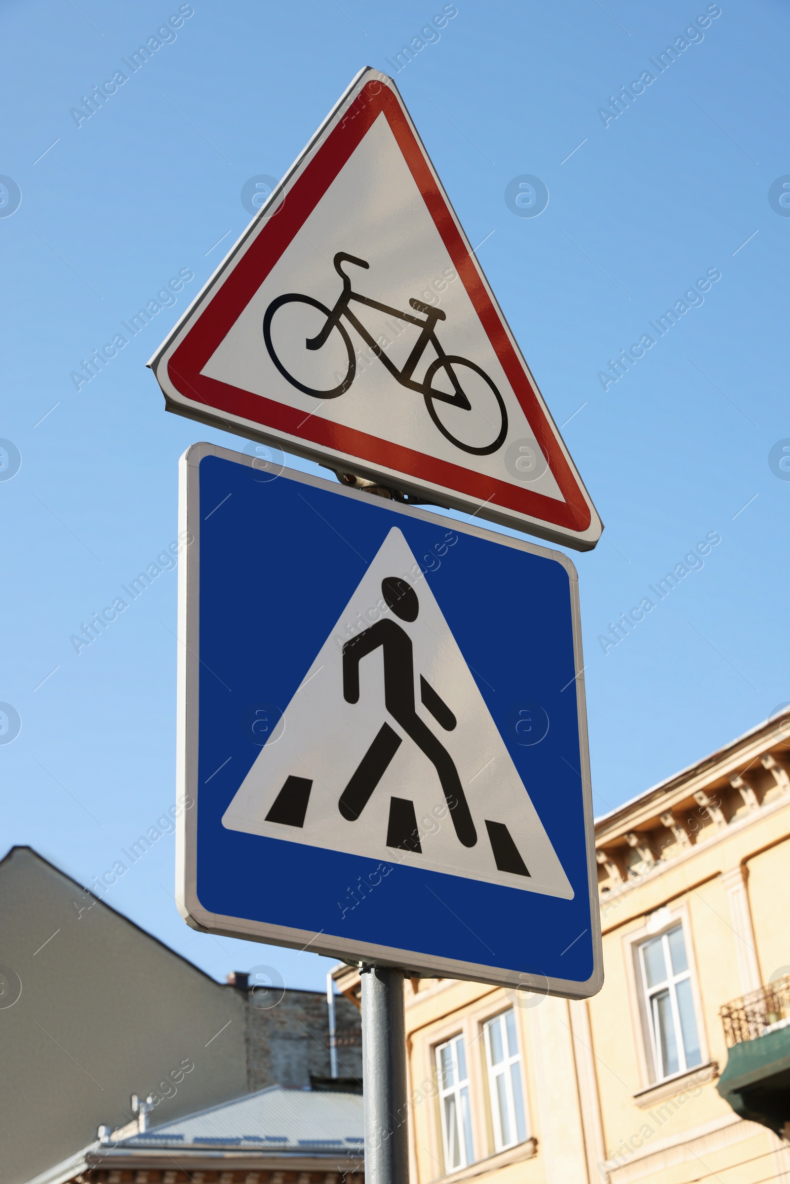 Photo of Traffic signs Pedestrian Crossing and No Bicycles on city street, low angle view