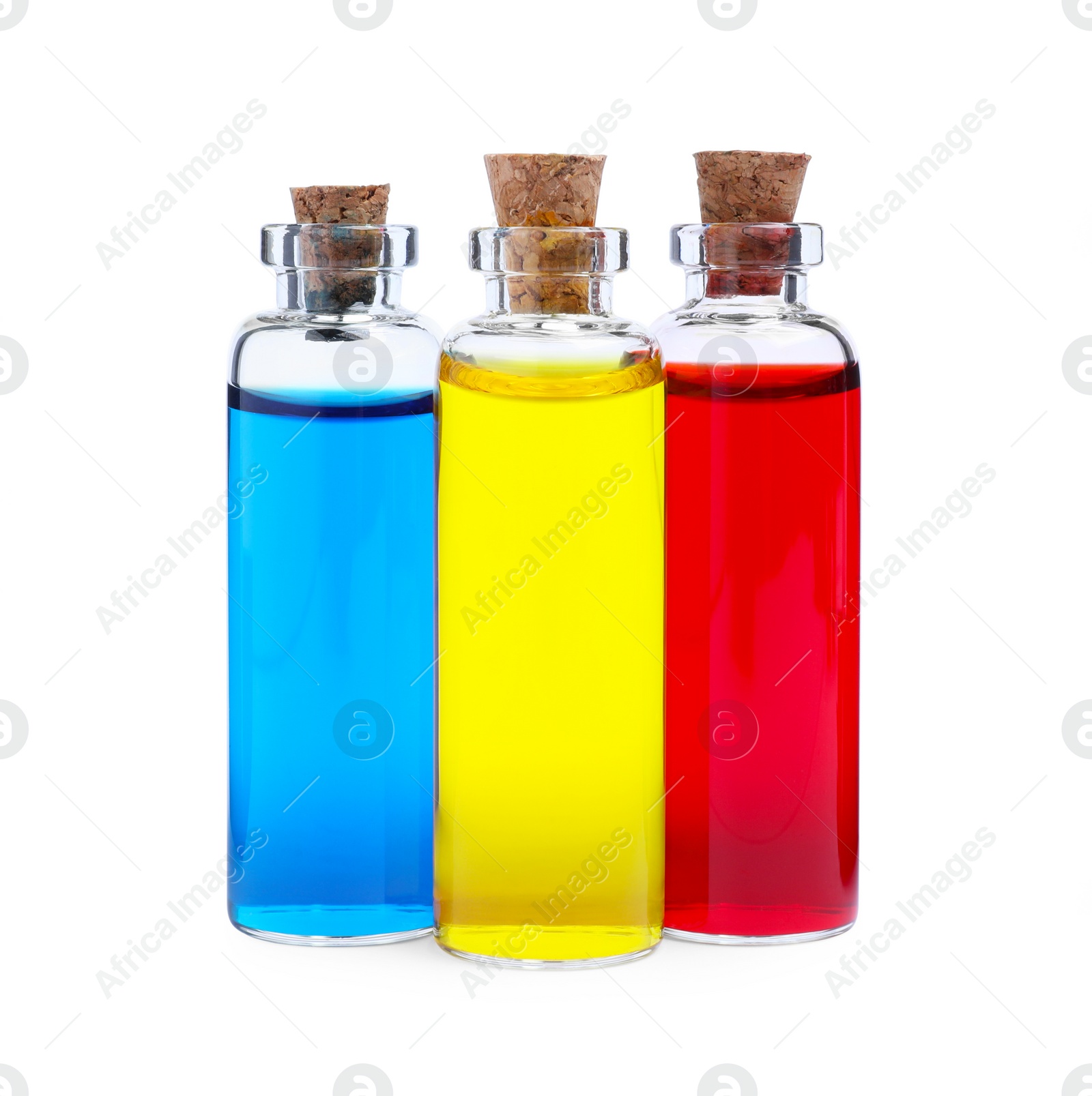 Photo of Glass bottles with different food coloring on white background