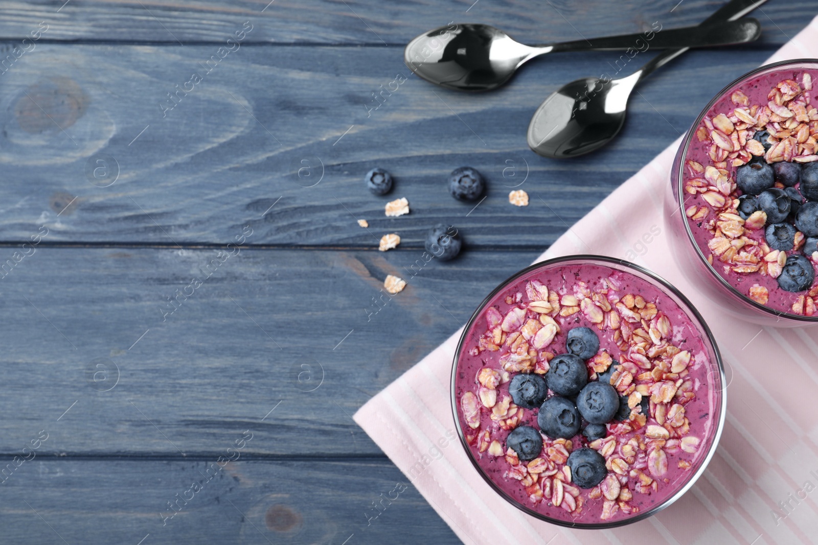 Photo of Flat lay composition with delicious blueberry smoothie on blue wooden background. Space for text