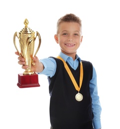 Photo of Happy boy in school uniform with golden winning cup and medal isolated on white