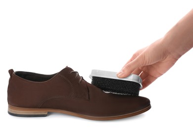 Photo of Woman cleaning suede leather shoe on white background, closeup. Footwear care accessory