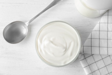 Glass jar with yogurt on table, top view