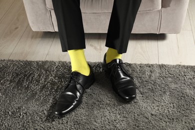 Man wearing stylish shoes and yellow socks indoors, closeup