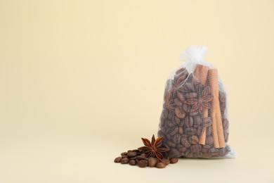 Photo of Scented sachet with coffee beans, anise and cinnamon on beige background, space for text