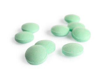 Many light green pills isolated on white