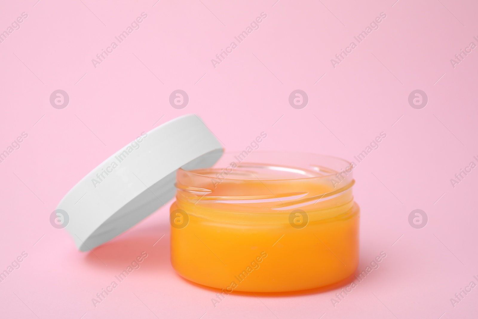 Photo of Open jar with petrolatum on pink background