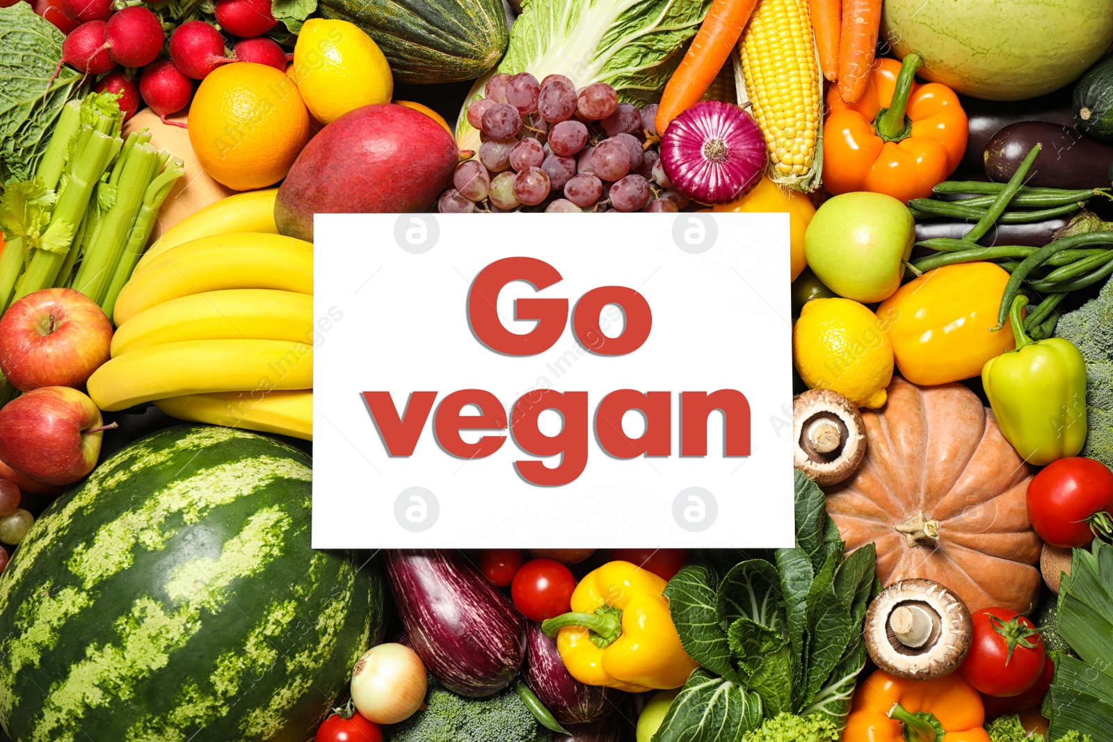 Image of Paper card with phrase Go Vegan, fresh vegetables and fruits, top view