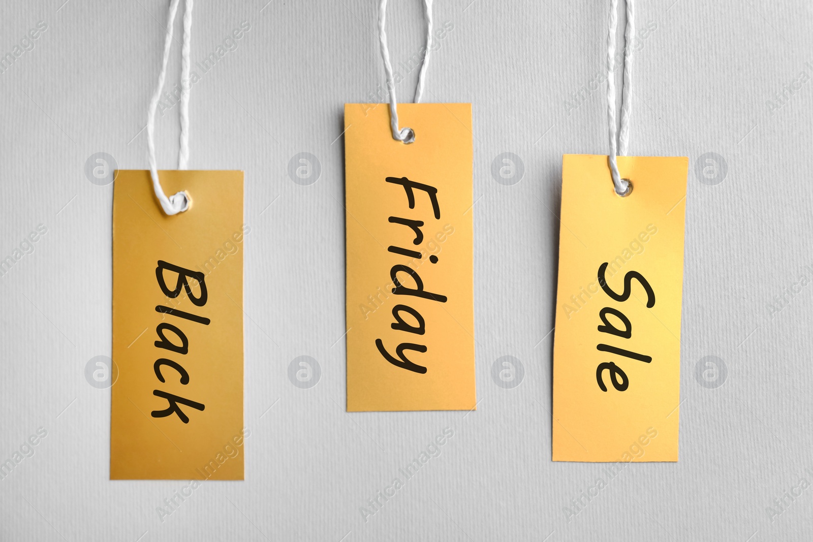 Photo of Blank golden tags on light background, top view. Black Friday concept