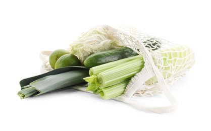 Photo of String bag with different vegetables isolated on white