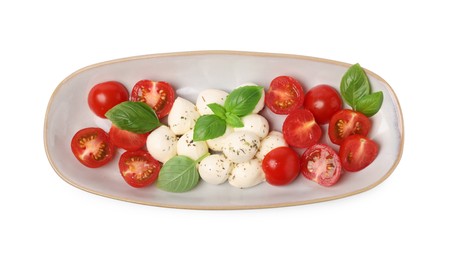 Photo of Plate of delicious Caprese salad with tomatoes, mozzarella, basil and spices isolated on white, top view