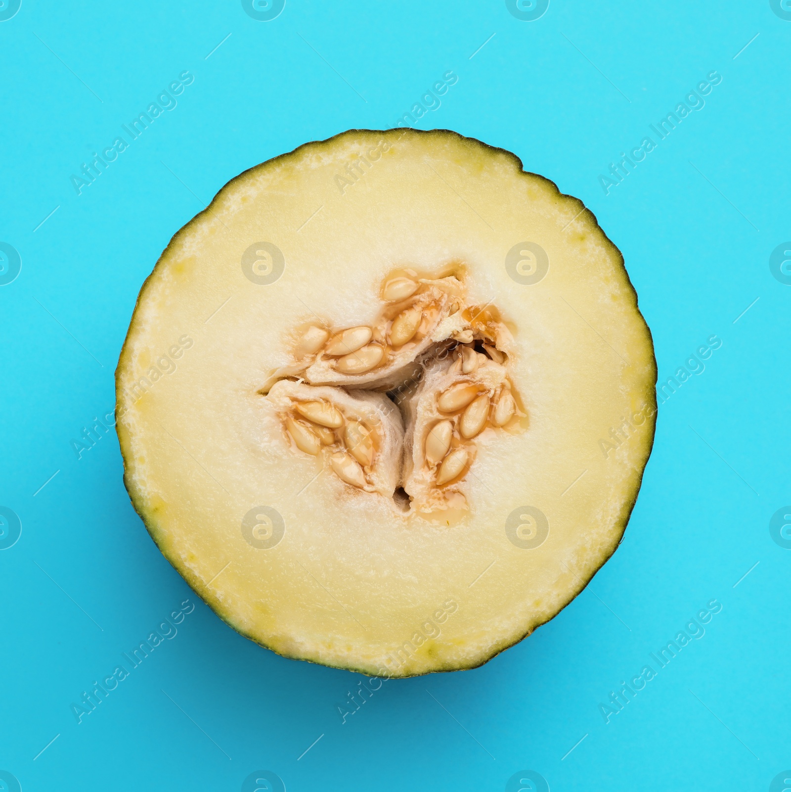 Photo of Half of ripe tasty melon on blue background, top view