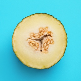 Photo of Half of ripe tasty melon on blue background, top view