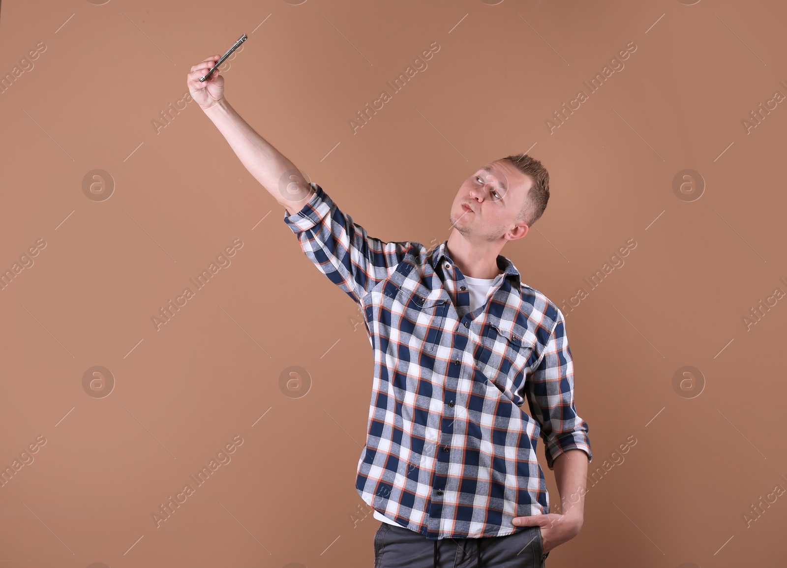 Photo of Handsome man taking selfie on color background