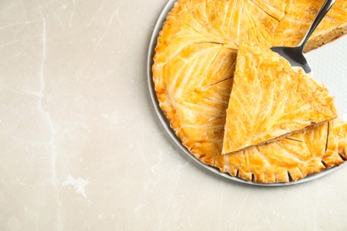 Photo of Traditional galette des rois on light grey marble table, top view. Space for text