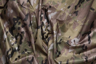 Photo of Texture of crumpled camouflage fabric as background, top view