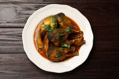 Photo of Tasty fish curry on wooden table, top view. Indian cuisine