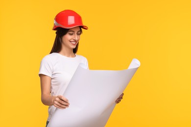 Photo of Architect in hard hat with draft on yellow background