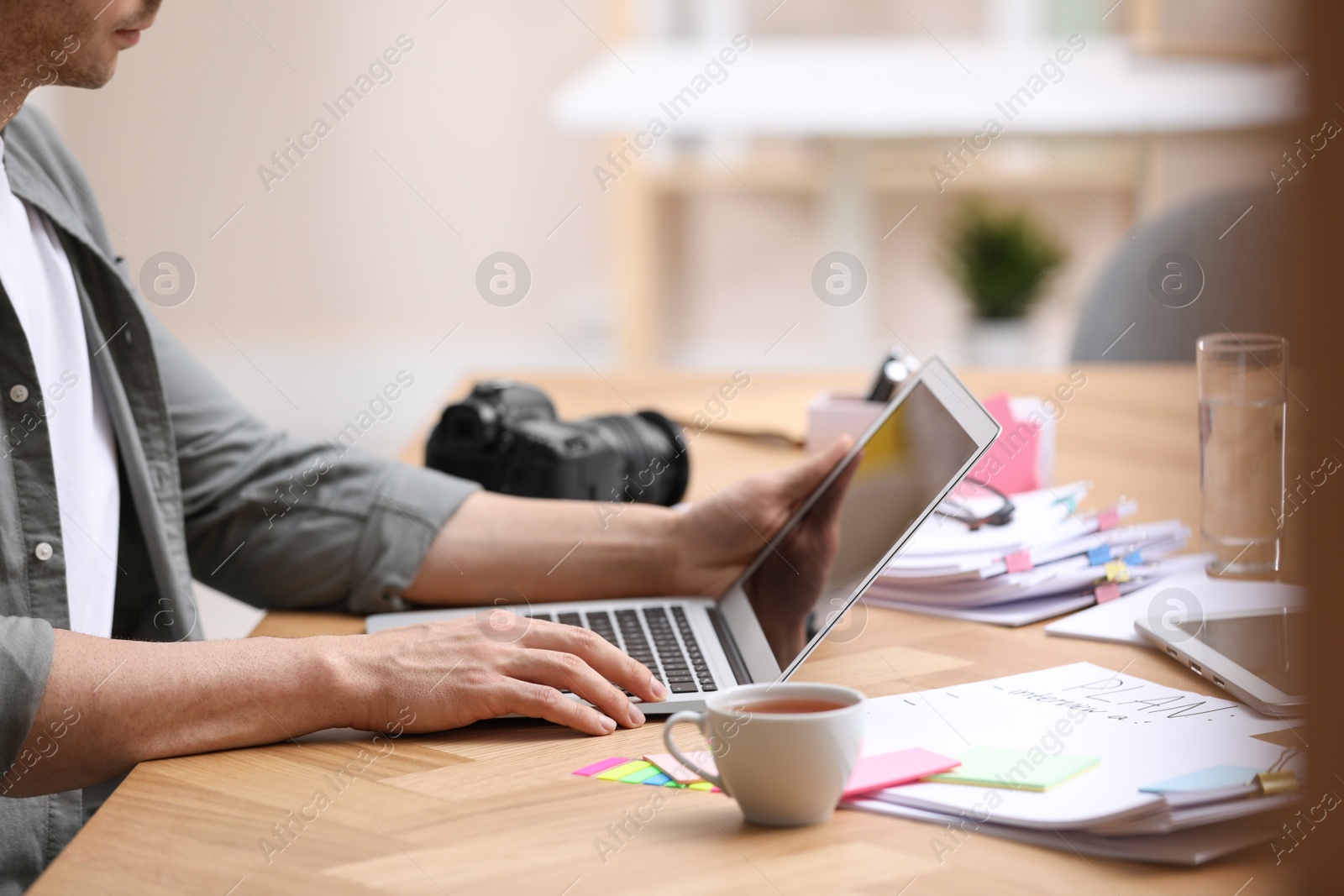 Photo of Professional journalist working with laptop in office, closeup