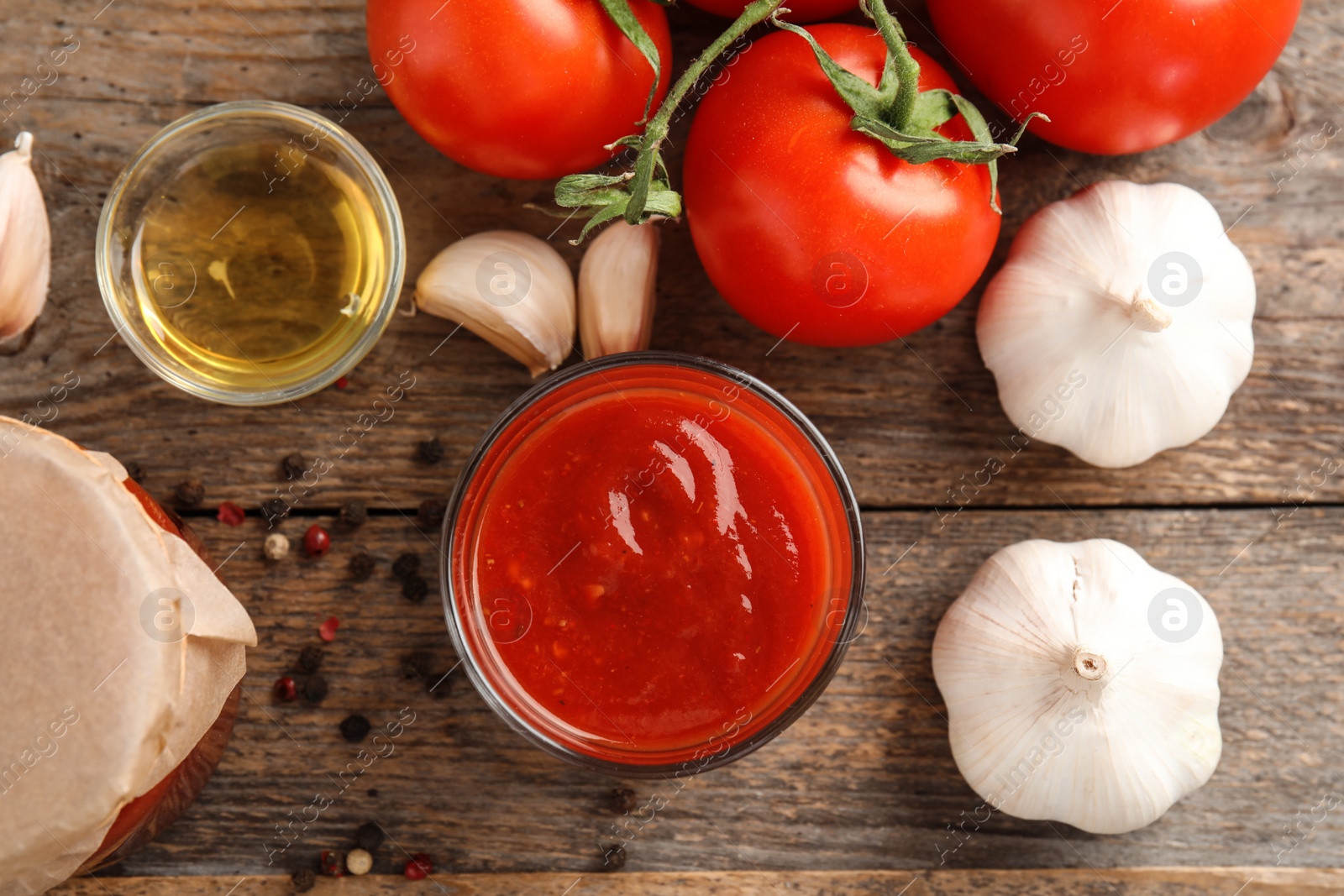 Photo of Flat lay composition with glass of tomato sauce, oil and vegetables on wooden table