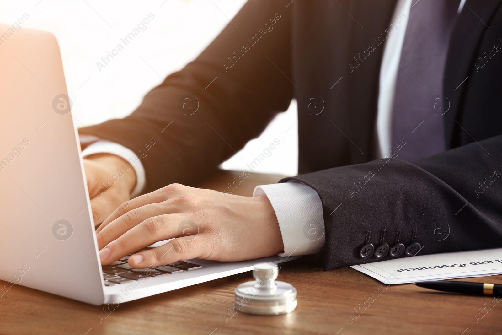 Image of Man working with laptop at table, closeup