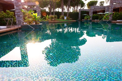 Outdoor swimming pool with umbrellas and sunbeds at resort