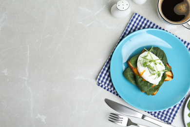 Delicious poached egg sandwich served on light grey marble table, flat lay. Space for text