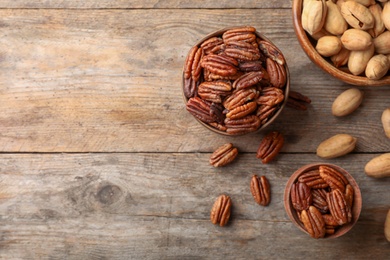 Photo of Flat lay composition with tasty pecan nuts on wooden table. Space for text