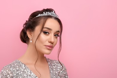 Photo of Beautiful young woman wearing luxurious tiara on pink background, space for text