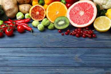 Photo of Fresh products rich in vitamin C on blue wooden table. Space for text