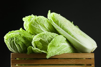 Fresh ripe Chinese cabbages in wooden crate on black background